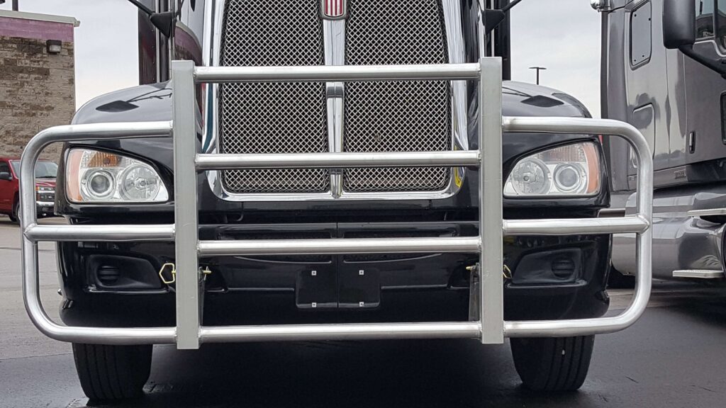 the front of a black truck with a metal bar